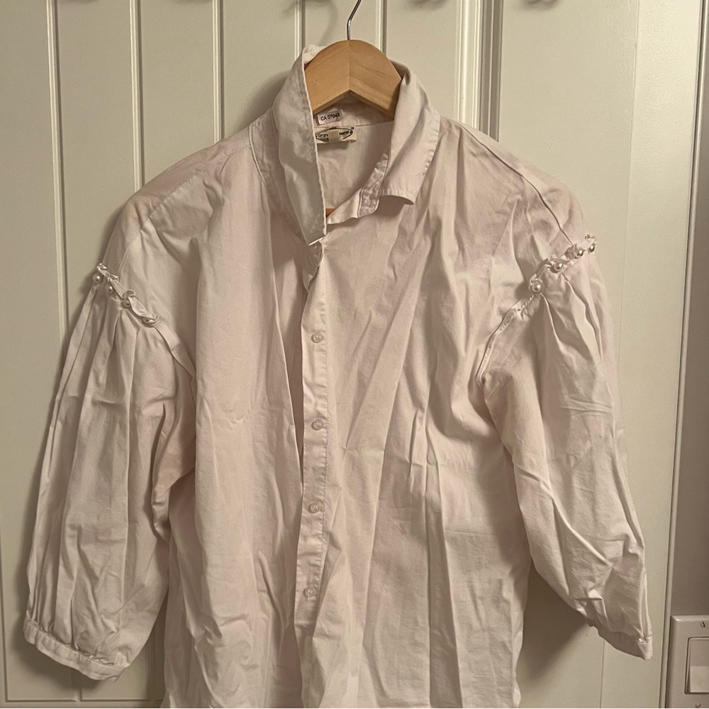 White shirt with pearls on the sleeves